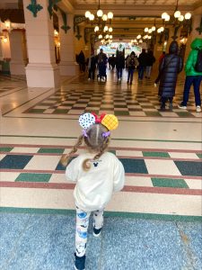Disneyland Park entrance toddler running wearing a sweatshirt in February